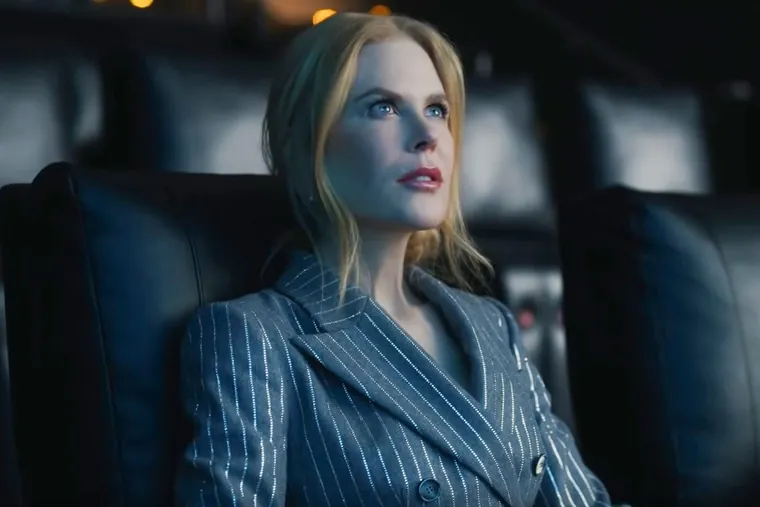 A frame from the AMC spot: Nicole Kidman in a pinstripe suit, seated in an empty auditorium and looking up at the screen.
